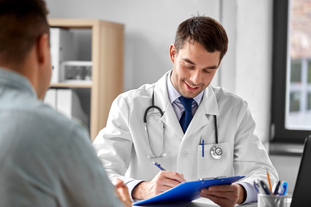 white male talking to doctor about knee pain