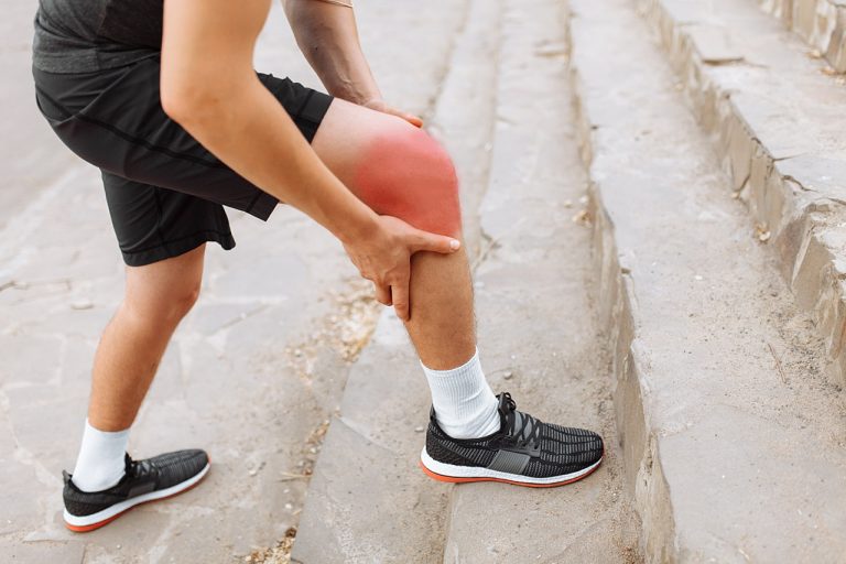 swollen knees experienced by man while walking up the stairs