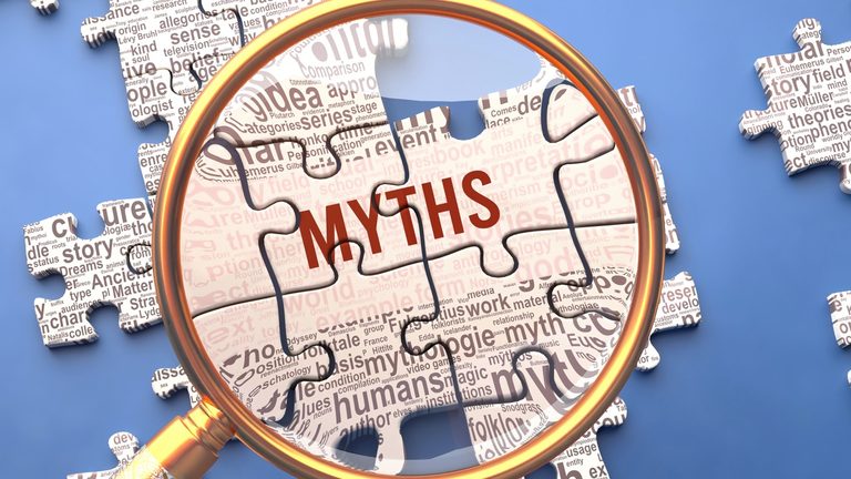 Magnifying glass focusing on the word myth surrounded by related text