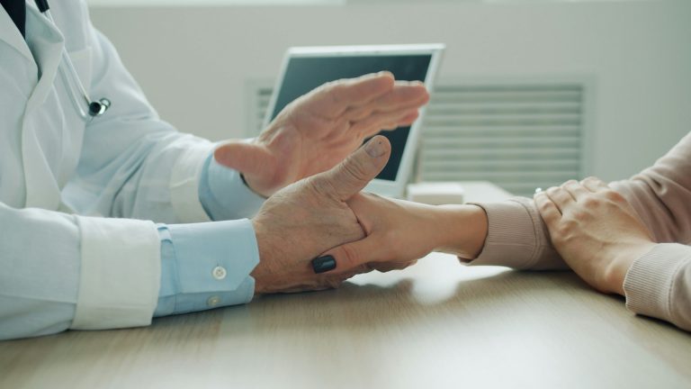 Doctor sitting with a patient in a clinic office, answering questions about nonsurgical knee treatment options