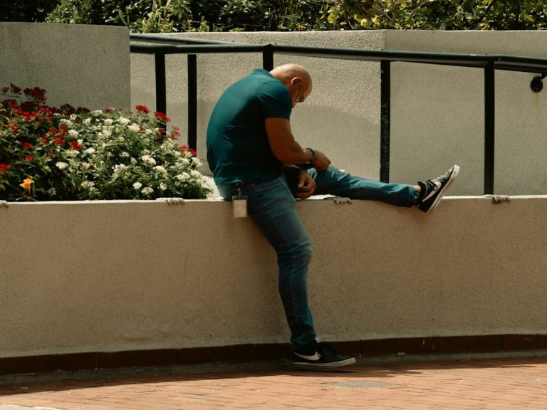 Person stretching leg outdoors representing chronic knee pain and changes in posture or movement