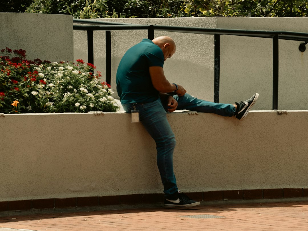 Person stretching leg outdoors representing chronic knee pain and changes in posture or movement