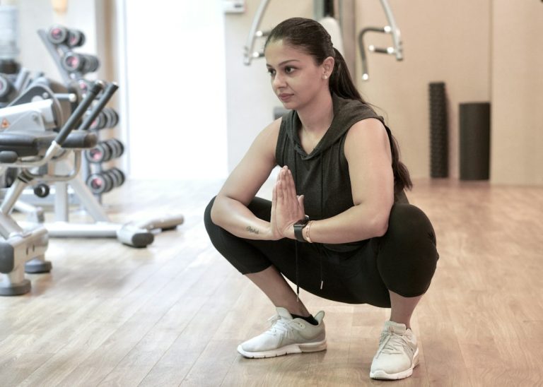 Person squatting during exercise representing knee pain when bending or squatting
