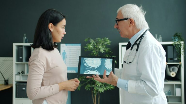 Doctor and patient reviewing images during evaluation for knee pain without a recent injury